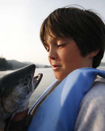 Young boy kissing a silver salmon