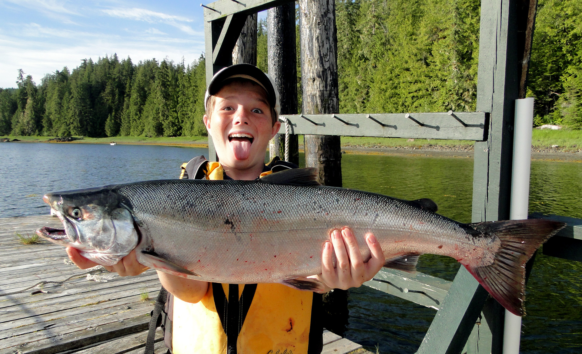 Young boy Ethan Ryter holds Alaska king salmon he caught at The Lodge at Whale Pass
