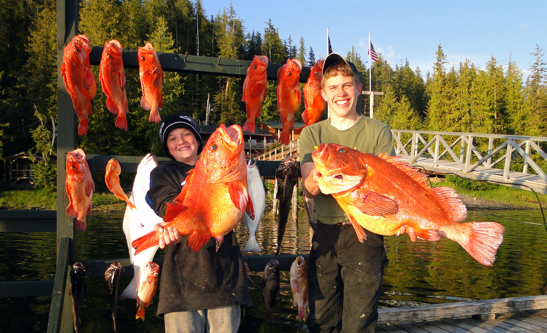 Two teenage boys display days catch of yelloweye and halibut in Alaska